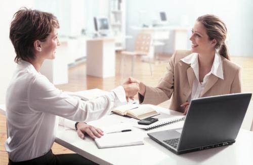 Two businesswoman sitting in office shaking hands. Concept for Avoiding Business Disputes Between Partners