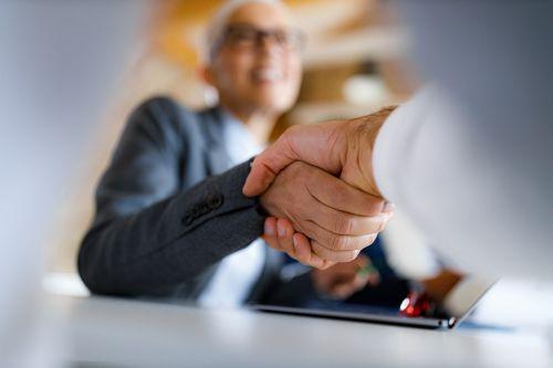 Close up of unrecognizable people shaking hands in the office. Concept ofr Can You Sue a Trustee for Mismanaging a Trust?