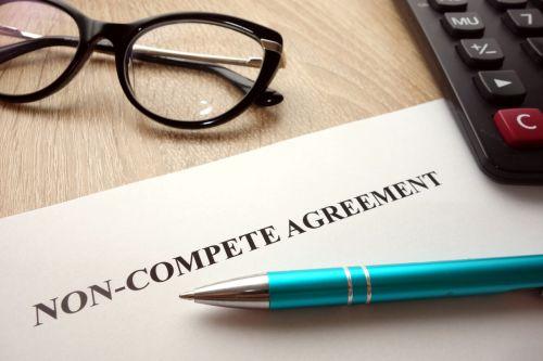 Non-compete agreement document for filling and signing on desk, business competition concept