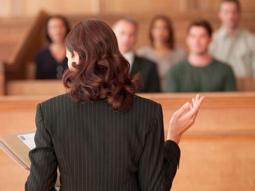 Female lawyer holding document and speaking to jury in courtroom concept for timeline of a litigated business dispute.